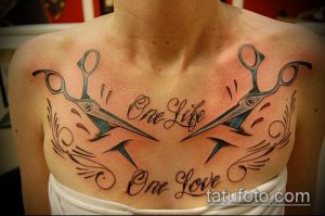 Фотография татуировки на груди с изображением ножниц и надписью "One Life, One Love". Необычный и символичный рисунок татуировки.