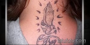 Фото тату молящихся рук в стиле олд скул с надписью 'Pray' на предплечье. Черно-серый рисунок татуировки.
