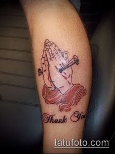 Фото тату на ноге: молящиеся руки, пронзенные гвоздями, с надписью 'Thank You'. Красный и черный рисунок.