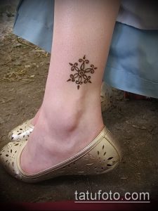 Фото тату мехенди на лодыжке, демонстрирующее простой, но элегантный узор в виде цветка. Идеально для тех, кто предпочитает минимализм и нежность.