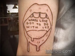Фото татуировки на руке, изображающей губы с надписью "What's love got to do with it?"