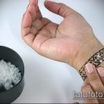 Фотография руки, на которой наносится татуировка. Виден процесс подготовки кожи и нанесения рисунка.