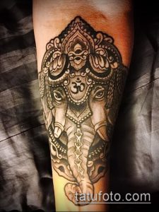 Фото тату Ганеши на руке, выполненное в технике blackwork с использованием тонких линий и мандалы. Детализированный и символичный рисунок.
