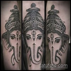 Фото тату Ганеши в стиле blackwork на руке. Детализированный рисунок головы слона с замысловатым головным убором и выразительными глазами.