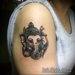 Небольшая татуировка Ганеши на плече, выполненная в черно-белых тонах. Милый и трогательный дизайн.