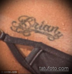Фото тату с именем 'Brian', выполненным в изящном каллиграфическом стиле. Черно-серый рисунок татуировки на коже.