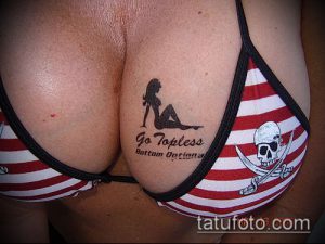 Фото тату на груди: силуэт девушки и надпись 'Go Topless Bottom Optional'. Черно-белый рисунок татуировки в провокационном стиле.