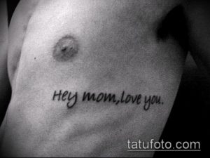 Фото тату на боку: простая надпись 'Hey Mom, love you.' черным цветом. Минималистичный стиль, искреннее выражение любви к матери.