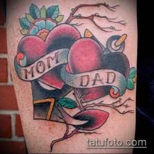 Фото тату на предплечье: два сердца с надписями 'Mom' и 'Dad', выполненные в стиле олд скул с яркими красными и синими цветами.