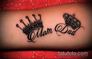 Фото тату: Короны над надписями 'Mom' и 'Dad' на предплечье, выполненные в стиле blackwork.