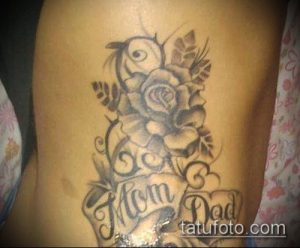 Фото тату на руке с изображением розы и надписей 'Mom Dad'. Черно-белая татуировка с детальной прорисовкой цветка.