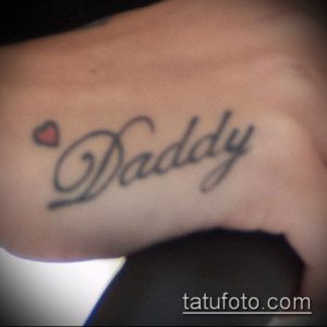 Фото тату на руке: надпись 'Daddy' с маленьким сердечком, черно-белая татуировка, простой и элегантный дизайн.