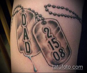 Фото татуировки с изображением двух жетонов с надписями 'DAD' и датой '2 15 08', выполненной в черно-серых тонах. Стильный и минималистичный рисунок татуировки.