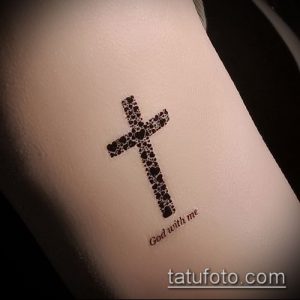 Фото тату: маленький крест, составленный из точек, с надписью 'God with me', минимализм, религиозная татуировка.