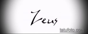 Черно-белое фото татуировки с именем "Zeus", выполненной стильным шрифтом. Подходит для вдохновения мужских татуировок с именами.