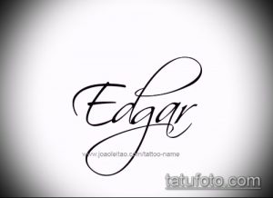 Черно-белое фото татуировки с именем 'Edgar', выполненной в изящном каллиграфическом стиле с декоративными элементами. Идеально для вдохновения.
