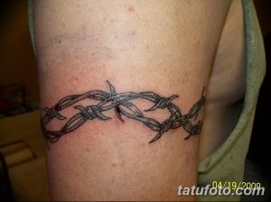 Фото тату: реалистичная татуировка колючей проволоки на предплечье. Детализированный рисунок с тенями и текстурой.