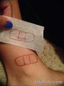 Фото минималистичной татуировки пластыря на коже. Необычный и провокационный рисунок татуировки, выполненный в красном цвете.