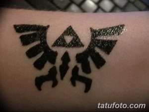 Фото тату символа Трифорс из игры Zelda на запястье. Простой черно-белый рисунок татуировки в минималистичном стиле.