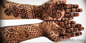 Фото тату мехенди на обеих руках, демонстрирующее симметричные восточные узоры, выполненные в коричневых тонах. Детализированные рисунки покрывают ладони и предплечья.
