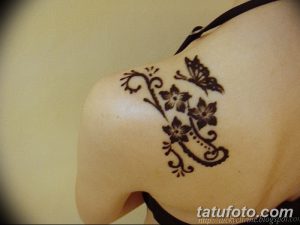 Фото тату хной на лопатке с изображением бабочки, цветов и завитушек. Красивый и женственный рисунок.