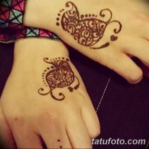 Фото тату мехенди на руках двух девушек. Изящный узор в форме сердца с точками и завитушками, выполненный в коричневых тонах.