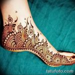 Фото тату мехенди на ступне, выполненное в коричневых тонах. Изящные завитки, цветочные элементы и точки создают красивый и женственный рисунок.