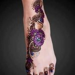 Фото тату хной с яркими фиолетовыми цветами на стопе. Идеально для создания яркого и запоминающегося образа.
