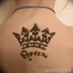 Фото тату хной на спине с изображением короны и надписью 'Queen'. Элегантный и стильный рисунок, выполненный в коричневых тонах.