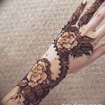 Фото тату хной: рука, украшенная сложным цветочным узором, с розами и ажурными элементами. Идеально для вдохновения дизайна мехенди.