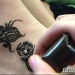 Фото тату мехенди на запястье, с изображением двух роз, украшенных блестками. Детализированный рисунок в коричневых тонах.