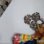 Фото эскиза тату мехенди с тремя розами, нарисованными на листе бумаги. Детализированный рисунок с использованием коричневых тонов.