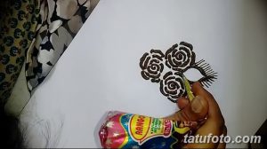 Фото эскиза тату мехенди с тремя розами, нарисованными на листе бумаги. Детализированный рисунок с использованием коричневых тонов.