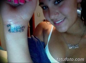 Фотография татуировки с надписью "Justin Bieber" на запястье девушки, выполненная простым шрифтом.