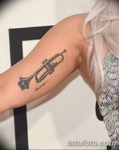Фото тату: реалистичная татуировка трубы, расположенная на предплечье. Черно-серые тона, детализированный рисунок, музыкальная тематика.
