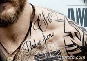 Фото тату на груди Тома Харди с надписью "Padre Fiero" и другими татуировками. Рисунок татуировки выполнен в каллиграфическом стиле.