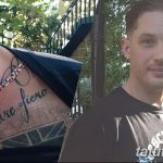 Фотография татуировки надписи "Padre Fiero" на шее мужчины, выполненной в черном цвете с элементами декоративного шрифта и небольшим фоновым рисунком.