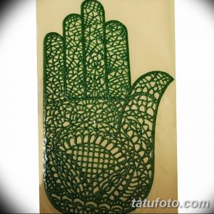 Фото изысканного эскиза тату хной на руке, выполненного в зеленом цвете с детализированным кружевным узором. Идеально для вдохновения.