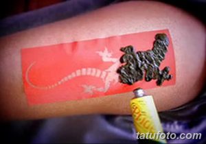 Фото процесса нанесения татуировки хной на руку, с использованием трафарета и тюбика с хной. Полезно для понимания техники и вдохновения.