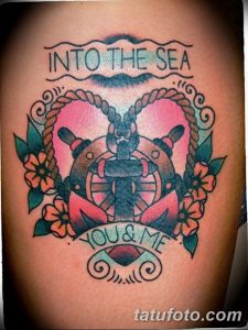 Фото тату на предплечье: якорь в форме сердца с надписью "Into the Sea", символизирует любовь к морю и приключениям.