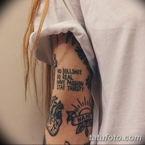 Фото тату на боку с надписью "NO BULLSHIT DO REAL HAVE PASSION STAY THIRSTY" и изображениями сердца и солнца.