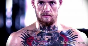 Фото тату гориллы на груди известного бойца MMA. Большая татуировка с реалистичным изображением головы гориллы, окруженной красными и черными элементами.