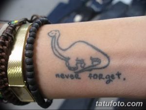 Фото минималистичной татуировки динозавра с надписью "Never Forget". Простой и стильный рисунок для любителей динозавров.