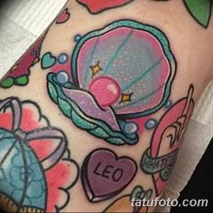 Фото яркой татуировки раковины с сердцем и надписью 'LEO'. Изображение выполнено в стиле new school с использованием ярких цветов и четких контуров.