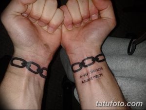 Фото парных татуировок цепей и надписи 'A man chooses, a slave obeys' на запястьях. Черно-белый рисунок.