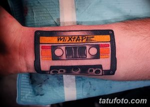 Фото тату кассеты с надписью "Mixtape" на запястье. Яркий, красочный рисунок татуировки в стиле олдскул, с детальной проработкой.