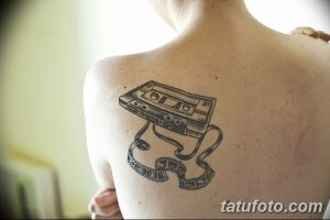 Фото тату с изображением аудиокассеты и вытекающей из нее ленты. Минималистичный и стильный рисунок татуировки на спине.