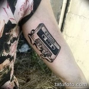 Фото тату: Черно-белая татуировка с изображением кассеты с надписью 'Nirvana'. Минималистичный стиль.