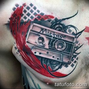 Фото татуировки кассеты с надписью 'Mixtape' на груди, выполненной в ярком стиле с использованием красных и серых оттенков и брызг краски.