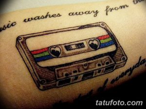 Фото тату кассеты с изображением двух сердец вместо катушек. Надпись "Music washes away from the soul of everyday life". Романтичный и символичный рисунок.